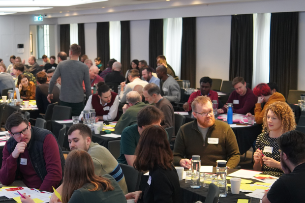 DDaT Fest attendees sat around tables working on an exercise.