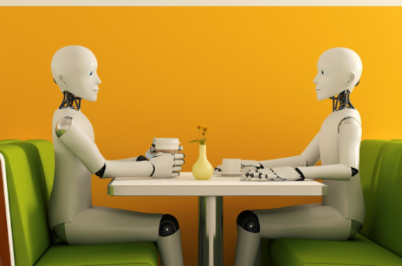 2 white humanoid robots sat at a table as if they are having a chat