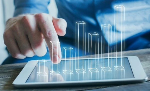 A hand pointing to a 3D bar graph projected upwards from a tablet.