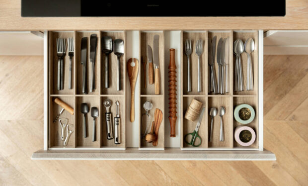 A drawer with cutlery and kitchen equipment neatly organised into compartments.